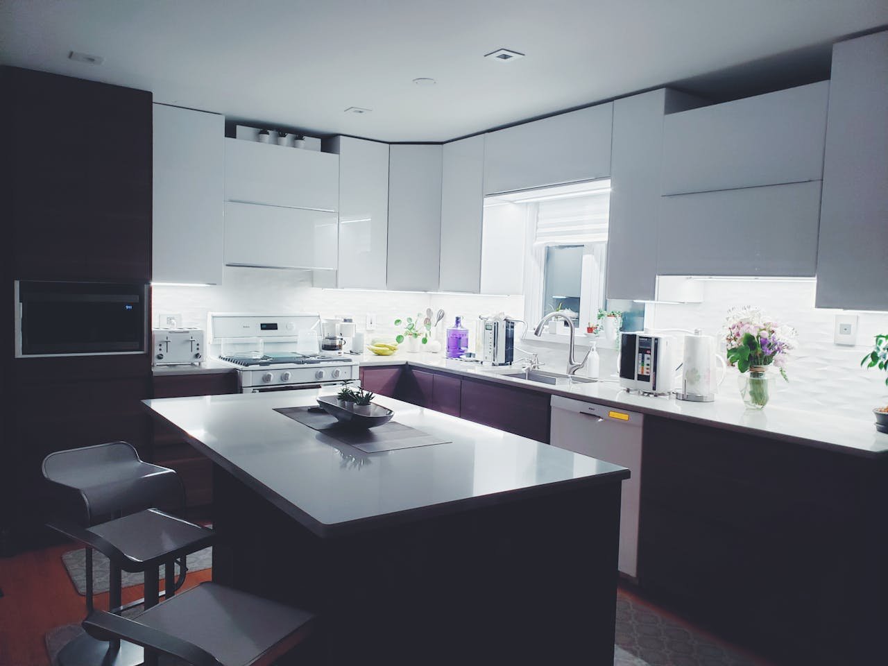 Contemporary kitchen interior with sleek white cabinets and island, perfect for a minimalist aesthetic.